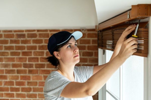 A woman showing how to take down blinds