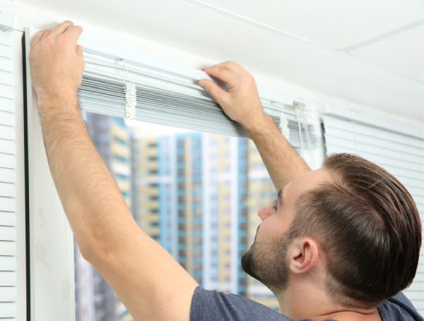 a man is showing how to replace blinds