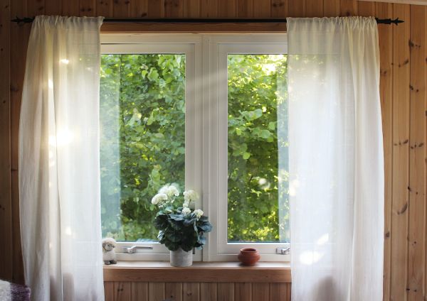 white curtains flowing down the winodw ( feature image of difference between curatins and drapes)