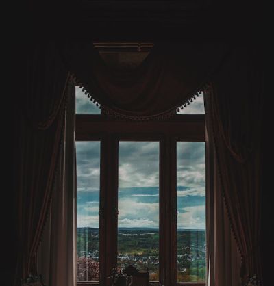 window in a room paired with elegant drapes. , offering a perfect sky view.