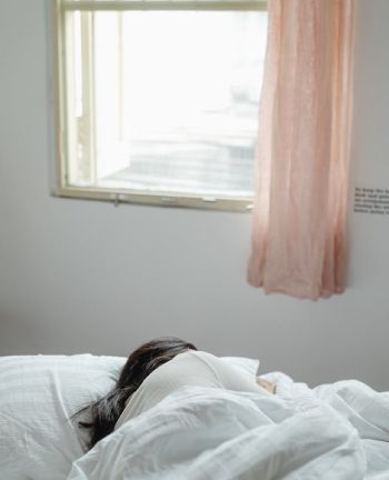 Girl peacefully sleeps in a room adorned with elegant window treatments.